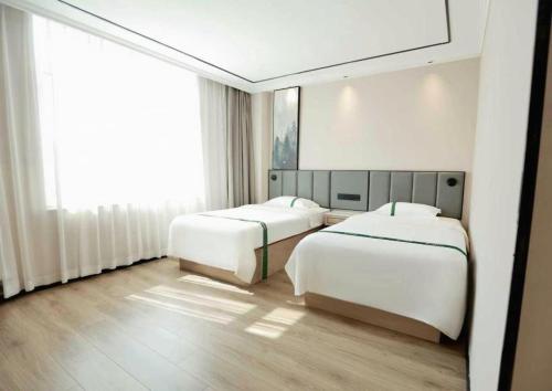a bedroom with two beds and a large window at GreenTree Inn Langfang Sanhe South Yingbin Road Express Hotel in Sanhe