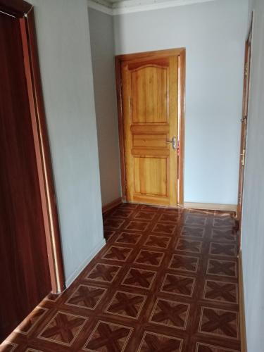 an empty hallway with a wooden door and a floor at Turkebaev 132 in Almaty