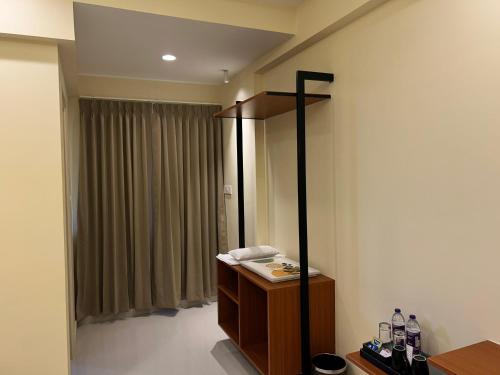 a room with a mirror and a dresser and a curtain at Felix Inn Boutique Hotel - Manyata Tech Park in Bengaluru