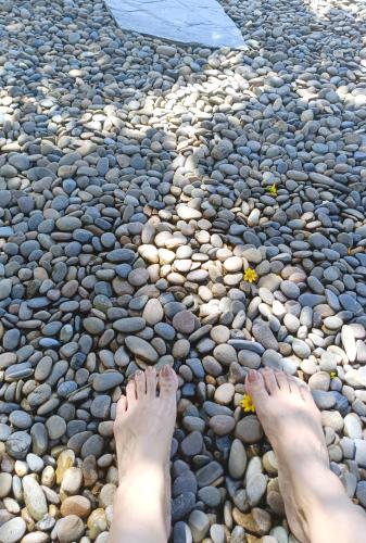 a persons feet on a pebble beach at Chombua MaeWang ชมบัว in Chiang Mai