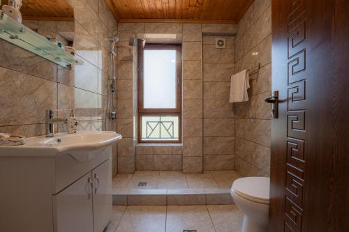a bathroom with a sink and a toilet and a window at Hotel and Restaurant "VILLA GIVISI" in Lagodekhi