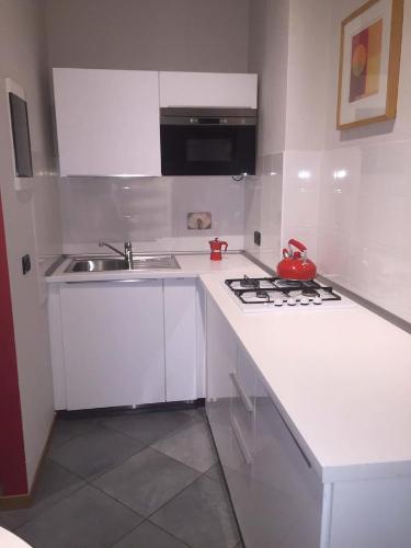 a white kitchen with a sink and a stove at Residenza Avogadro in Turin