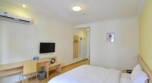 a room with a bed and a desk and a tv at 7 Days Inn Suzhou Wangting Pearl Commercial Plaza in Suzhou