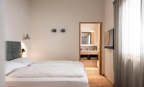 a bedroom with two white beds and a mirror at Florerhof in Schenna