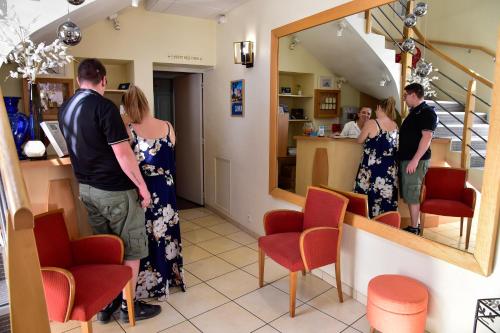 a group of people waiting at a counter in a salon at Logis Hôtel Le Pélican & son restaurant in Vernantes