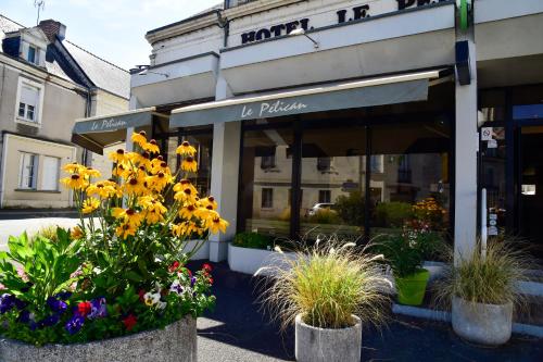 a store with flowers and plants in front of it at Logis Hôtel Le Pélican & son restaurant in Vernantes