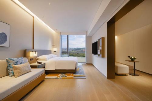 a hotel room with a bed and a couch at Hyatt Place Kunming South Railway Station in Kunming