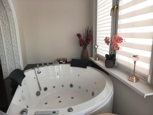 a white bath tub in a room with a window at Apartament w Tucholi in Tuchola