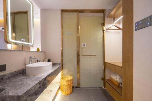 a bathroom with a sink and a shower at Huazhu Yiye Jiyu Hotel in Shanghai