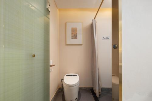 a bathroom with a toilet and a shower at Huazhu Yiye Jiyu Hotel in Shanghai