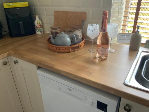 a counter top with a bottle of wine and a glass at Abbies Place in New Mills