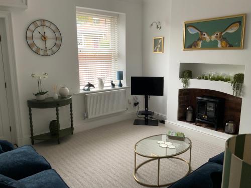 a living room with a couch and a fireplace at Abbies Place in New Mills