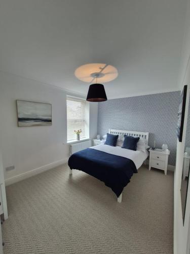 a bedroom with a large bed with blue pillows at Abbies Place in New Mills