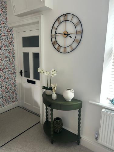 a clock on a wall next to a door at Abbies Place in New Mills
