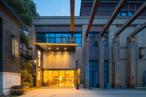 a building with a large glass door with lights at Huazhu Yiye Jiyu Hotel in Shanghai