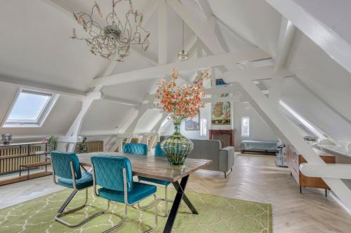 a dining room with a table and blue chairs at Top floor appartment Edam in Edam