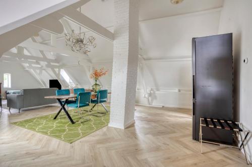 a living room with a table and blue chairs at Top floor appartment Edam in Edam