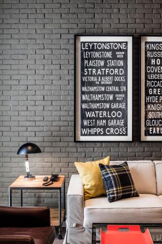 a living room with a couch and a brick wall at Midtown Apartments in Barcelona