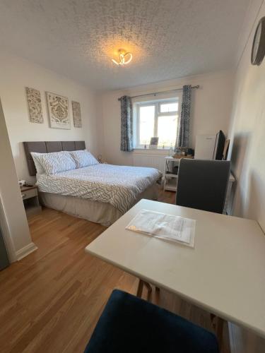 a room with a bed and a table with a tableablish at The Bungalow by SJP in Northamtonshire