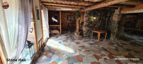Una habitación con suelo de baldosas y pared de piedra. en Vilimu Sodyba - Stone Hall, en Kriukai