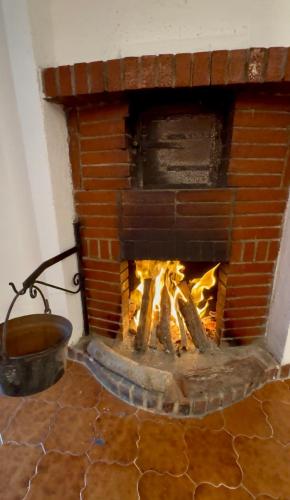 a brick fireplace with a fire in it at Casa Altolaterra in Tagliacozzo
