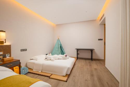 a bedroom with two beds with stuffed animals on it at Huazhu Yiye Jiyu Hotel in Shanghai