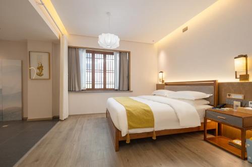 a bedroom with a large bed and a window at Huazhu Yiye Jiyu Hotel in Shanghai