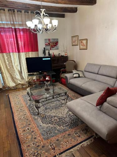a living room with a couch and a coffee table at la maison d'Emilia verdure et murmure de l'eau 