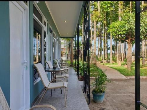 a patio with chairs and a table on a building at Jatimas Hijau Hotel & Villa in Kopo 2