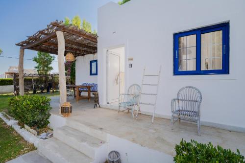 a patio with two chairs and a table and a building at Eco Beach And Magic Garden Hotel in Gennadi