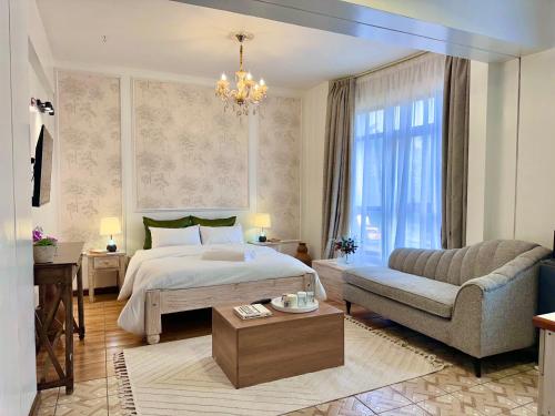 ein Schlafzimmer mit einem Bett, einem Sessel und einer Couch in der Unterkunft Yallo Residency in Nairobi