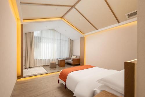 a hotel room with a bed and a large window at Huazhu Yiye Jiyu Hotel in Shanghai