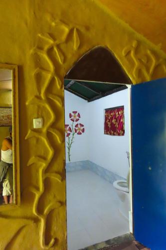 a bathroom with a toilet and a yellow wall at Wild Planet Eco Retreat in Bhurkīā