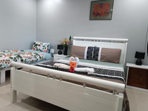 a white bed with a stuffed animal sitting on it at Vila Backpackers in Tatafo