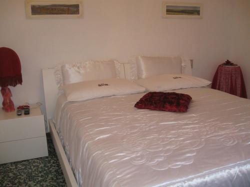 a white bed with white pillows on top of it at B&B Casa Delle Rose in Antria