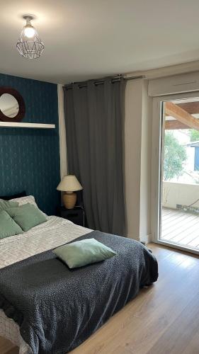 une chambre avec un lit et une grande fenêtre dans l'établissement Chez Aurélie & Mathieu studio dans ancienne maison rénovée proche du Lac, à Dompierre-sur-Yon
