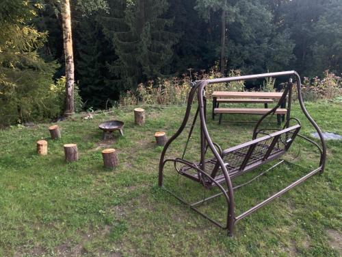 a park bench and a picnic table in the grass at Apartmán Mariánská Hora in Albrechtice v Jizerských horách