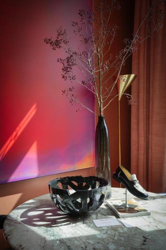 a vase with branches in it sitting on a table at De L’Europe Amsterdam – The Leading Hotels of the World in Amsterdam