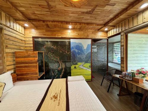 a bedroom with a bed and a large painting on the wall at Xuan Son Lakeside Bungalow in Ninh Binh