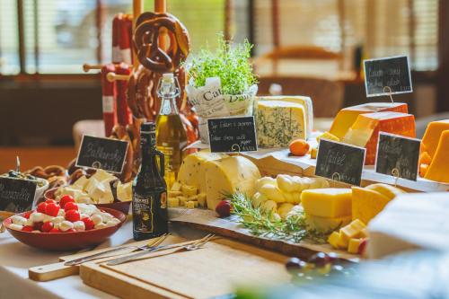 a table with cheese and other foods on it at Grand Palace Brno - Czech Leading Hotels in Brno
