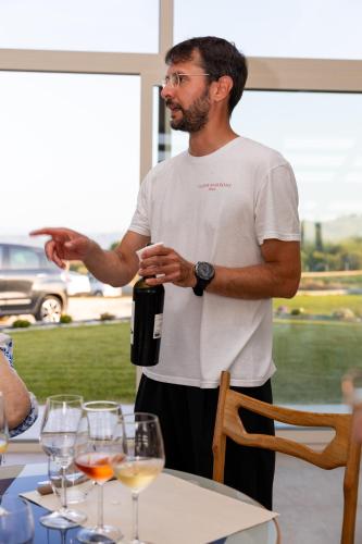 a man standing next to a table with a bottle of wine at Vigne Marrone B&B in Fossacesia