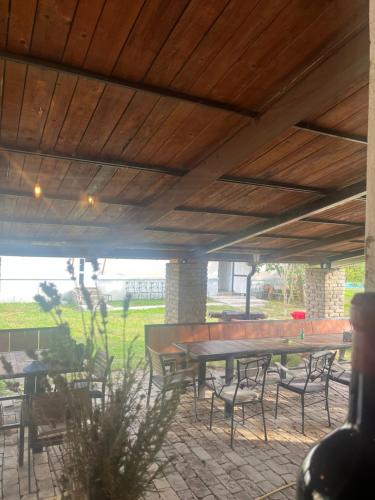 a patio with tables and chairs under a wooden ceiling at Etno imanje Dorf in Ravno Selo