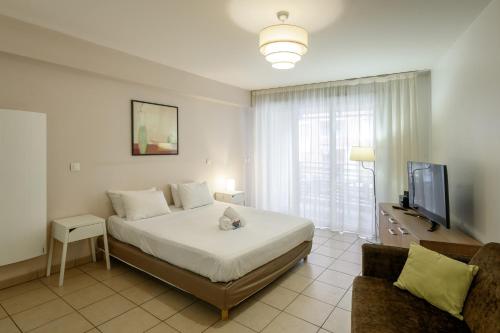 a bedroom with a bed and a tv and a couch at Residhotel Toulouse Centre in Toulouse
