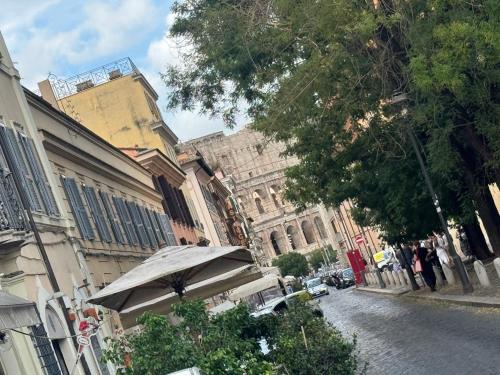 a city street with an umbrella and buildings at Domus Colosseum, detached house just few steps from the Colosseum in Rome
