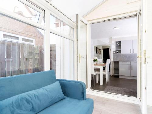 a living room with a blue couch and a large window at Prime House in Middlesbrough