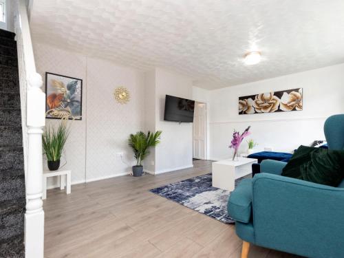 a living room with a blue couch and a tv at Prime House in Middlesbrough