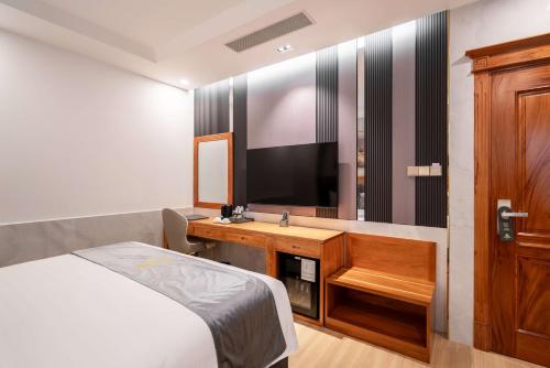 a hotel room with a bed and a television at Le Saigon Grand Hotel in Ho Chi Minh City
