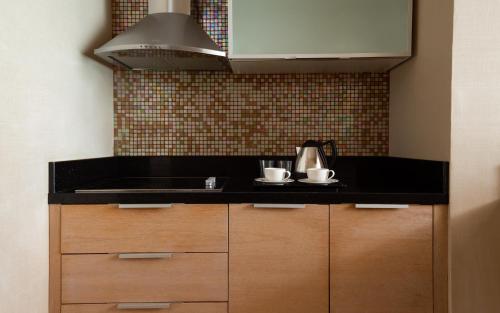 a kitchen with a black counter top and a sink at Badamdar Hotel and Residences in Baku