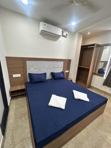 a bedroom with a blue bed with two white pillows at Hotel VK in Beās