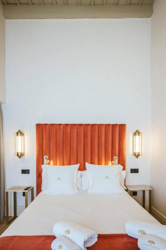 a bedroom with a large bed with two white pillows at Hotel Boutique Casas de Santa Cruz in Seville